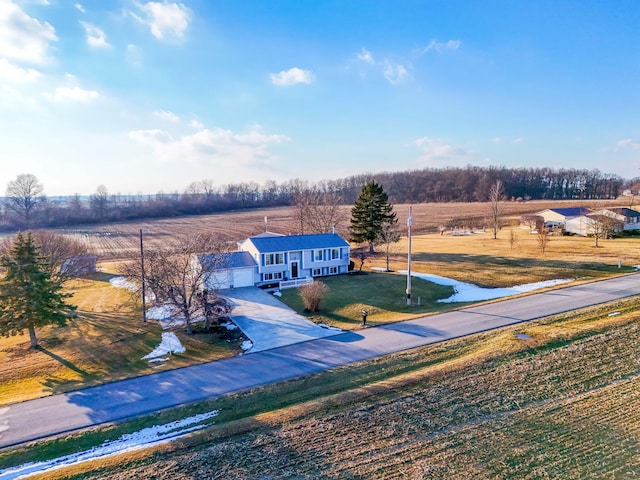 raised ranch with metal roof, concrete driveway, a front lawn, and an attached garage