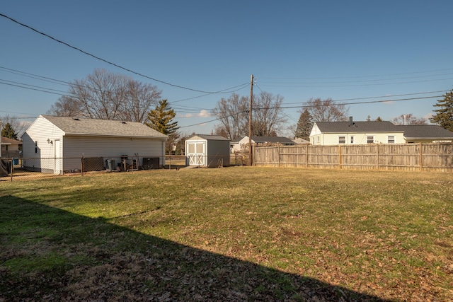 view of yard featuring a fenced backyard, an outdoor structure, and a storage shed