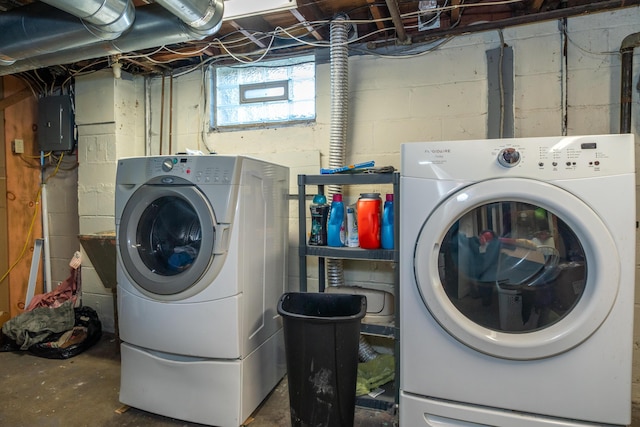 clothes washing area with laundry area, electric panel, and washer and clothes dryer