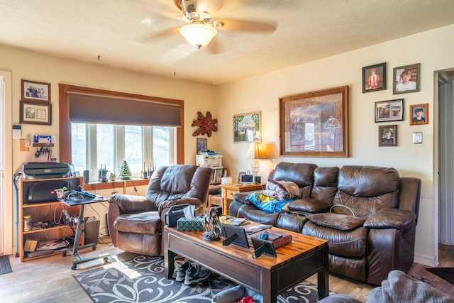 living room featuring light wood-style floors, ceiling fan, and a textured ceiling