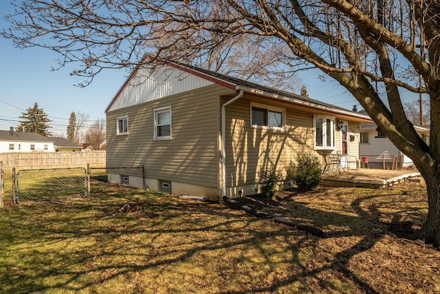 view of side of home featuring fence and a yard