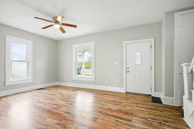foyer entrance with wood finished floors, a ceiling fan, and baseboards