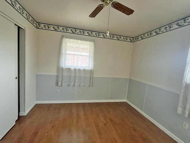 spare room with ceiling fan and wood finished floors