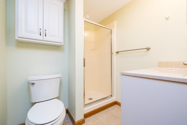 bathroom with tile patterned flooring, walk in shower, vanity, and toilet