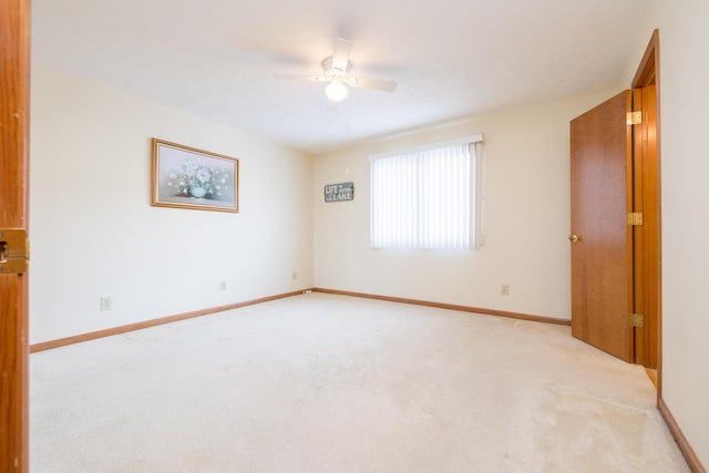 carpeted spare room with ceiling fan