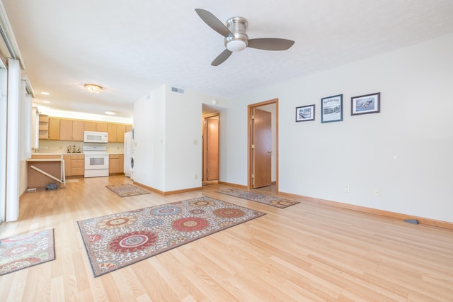 unfurnished living room with ceiling fan and light wood-type flooring