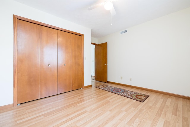 unfurnished bedroom featuring light hardwood / wood-style floors, a closet, and ceiling fan