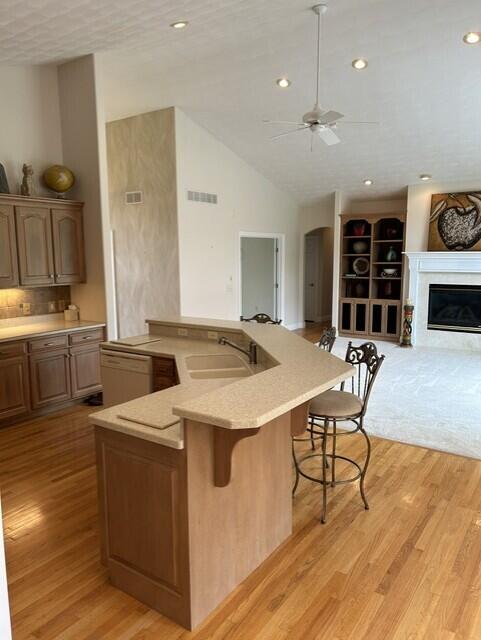 207 Meadowbrook Ln, Saint Marys, OH 45885 - kitchen with a sink, open floor plan, a breakfast bar, light wood-style flooring, and a ceiling fan