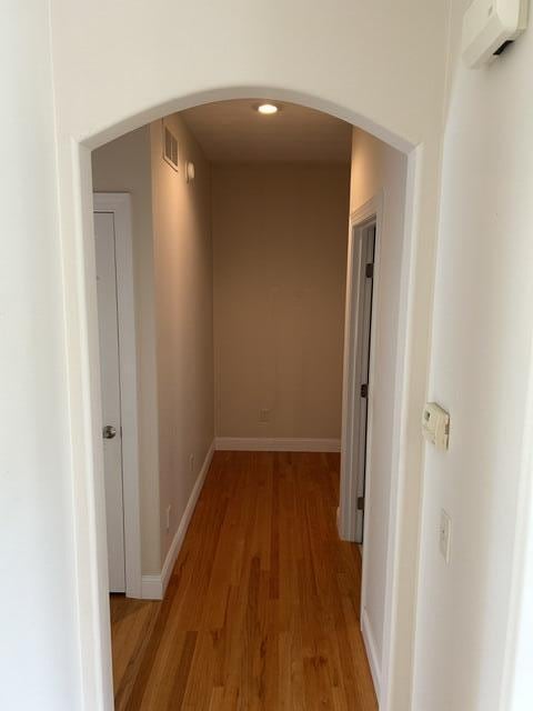 207 Meadowbrook Ln, Saint Marys, OH 45885 - hallway featuring light wood finished floors, arched walkways, and baseboards