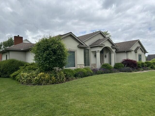 207 Meadowbrook Ln, Saint Marys, OH 45885 - view of front of property featuring stucco siding, a front lawn, and a chimney