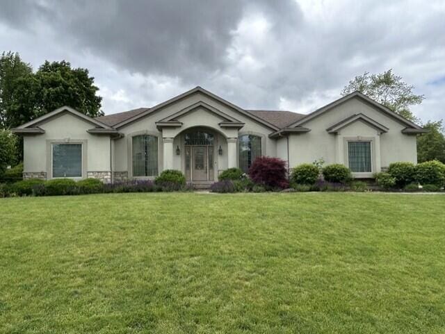 207 Meadowbrook Ln, Saint Marys, OH 45885 - ranch-style home with stucco siding, a front lawn, and stone siding