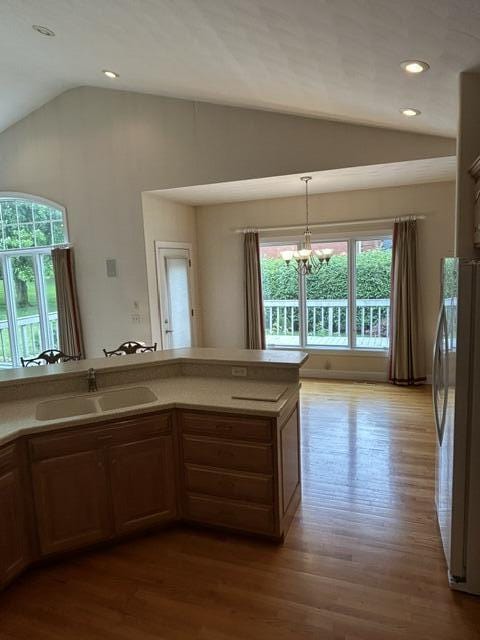 207 Meadowbrook Ln, Saint Marys, OH 45885 - kitchen with a sink, lofted ceiling, freestanding refrigerator, wood finished floors, and a chandelier