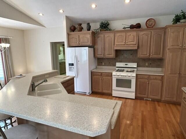 207 Meadowbrook Ln, Saint Marys, OH 45885 - kitchen with white appliances, a sink, light countertops, light wood-style floors, and recessed lighting