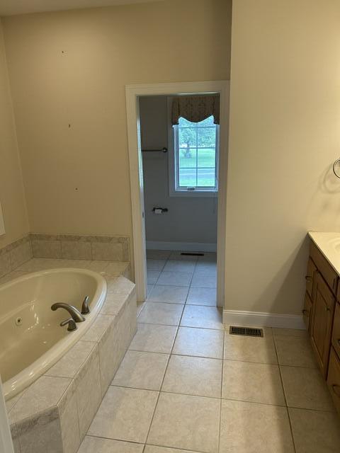 207 Meadowbrook Ln, Saint Marys, OH 45885 - bathroom featuring vanity, tile patterned flooring, a jetted tub, and baseboards