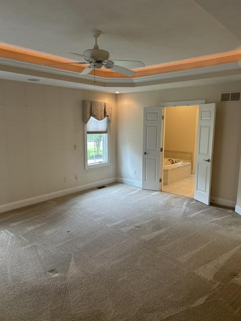 207 Meadowbrook Ln, Saint Marys, OH 45885 - unfurnished bedroom with a raised ceiling, baseboards, carpet, connected bathroom, and ceiling fan