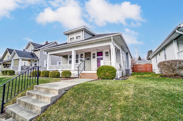 view of front of property with a porch, a front yard, cooling unit, and fence