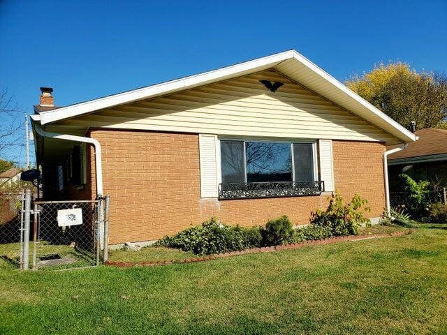 view of side of home with a lawn