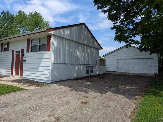 1124 Bookwalter Ave, New Carlisle, OH 45344 - view of property exterior with a detached garage, an outdoor structure, and board and batten siding