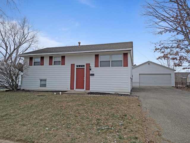 1124 Bookwalter Ave, New Carlisle, OH 45344 - raised ranch featuring a front lawn, a garage, a shingled roof, and an outdoor structure