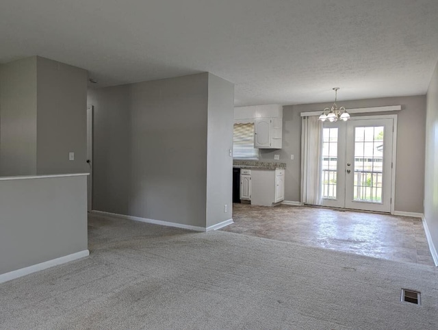 1124 Bookwalter Ave, New Carlisle, OH 45344 - unfurnished living room with a chandelier, baseboards, french doors, and light carpet
