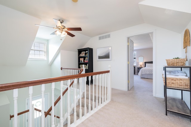 corridor with vaulted ceiling and light colored carpet