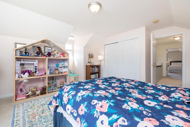 carpeted bedroom with vaulted ceiling and a closet