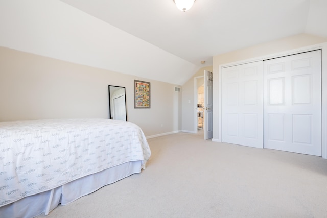 carpeted bedroom with vaulted ceiling and a closet