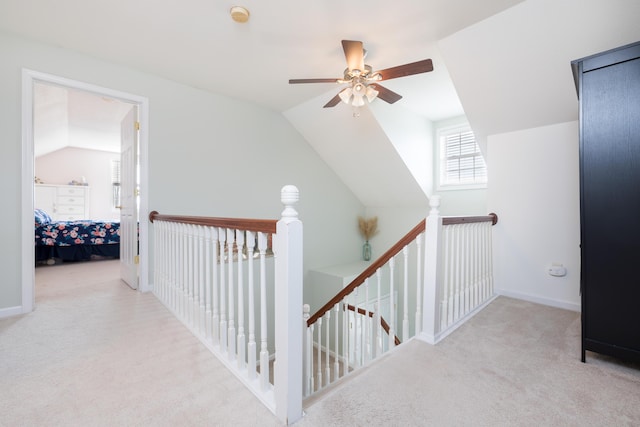 hallway with light colored carpet and vaulted ceiling