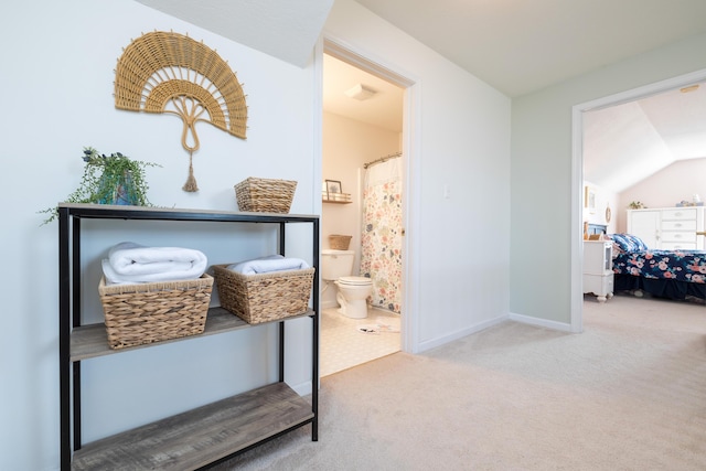 interior space with connected bathroom and vaulted ceiling