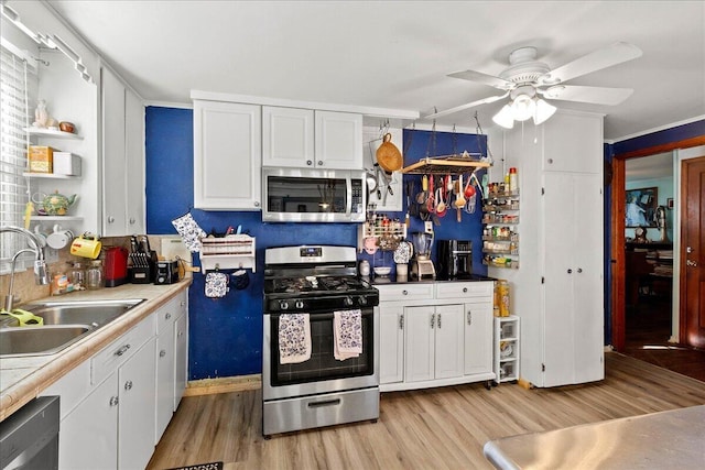 kitchen featuring ceiling fan, white cabinetry, appliances with stainless steel finishes, and a sink