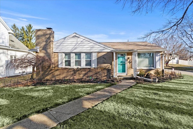 view of front of property with a front lawn, brick siding, and a chimney