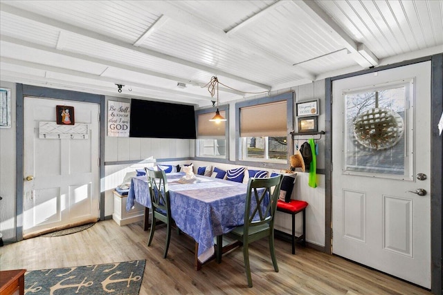 dining room featuring beam ceiling, wood finished floors, and baseboards