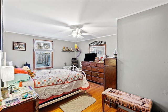 bedroom featuring ceiling fan, ornamental molding, and light wood finished floors