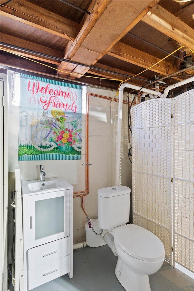 bathroom featuring vanity, toilet, and concrete floors