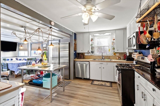 kitchen featuring plenty of natural light, stainless steel appliances, light wood-style floors, and a sink