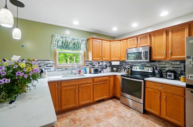 1820 Bishop Ln, Findlay, OH 45840 - kitchen featuring appliances with stainless steel finishes, a sink, light countertops, backsplash, and decorative light fixtures