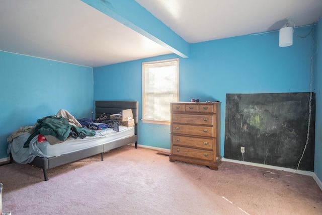 carpeted bedroom with beamed ceiling and baseboards