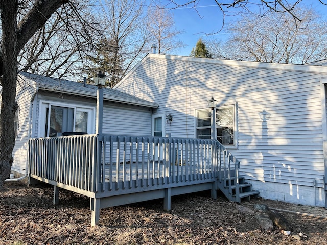 back of property featuring roof with shingles and a wooden deck