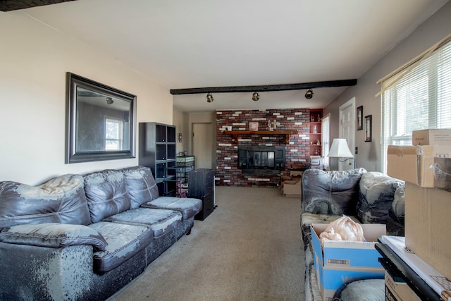 carpeted living area featuring a brick fireplace and rail lighting