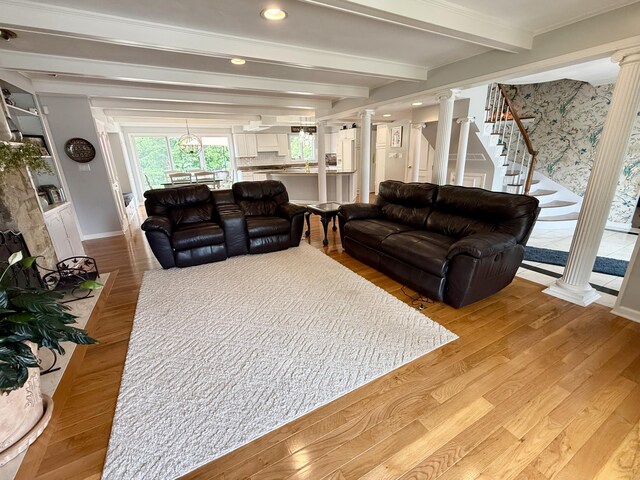 1337 Stratford Dr, Piqua, OH 45356 - living area with decorative columns, light wood-style flooring, beam ceiling, stairway, and baseboards