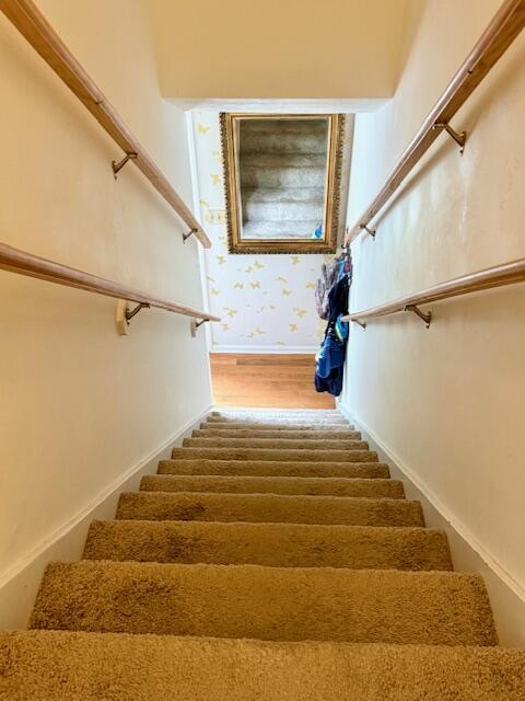 1337 Stratford Dr, Piqua, OH 45356 - staircase featuring wood finished floors, baseboards, and wallpapered walls