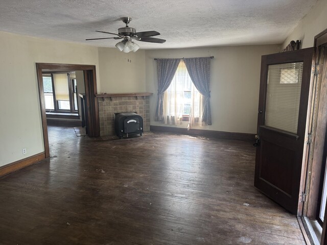 1108 N Fountain Blvd, Springfield, OH 45504 - unfurnished living room featuring a textured ceiling, a wood stove, wood finished floors, and ceiling fan