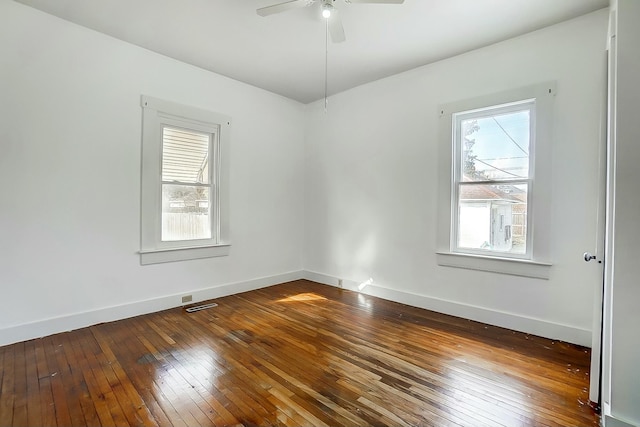 empty room featuring ceiling fan, dark wood-type flooring, and baseboards