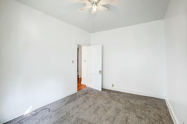 spare room with a ceiling fan, carpet flooring, and baseboards