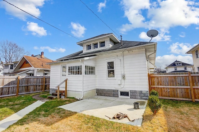 back of property featuring entry steps, a fenced backyard, a lawn, and a patio