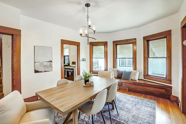 dining area with light wood finished floors and a notable chandelier