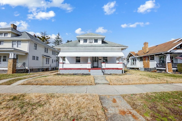 view of front of property featuring covered porch and a front yard