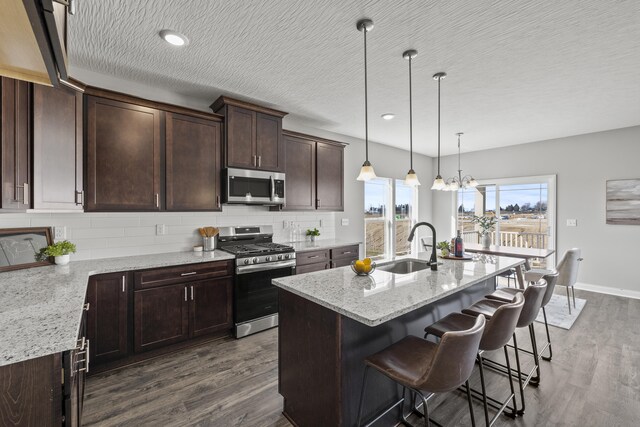 1304 Township Rd Unit 179, Bellefontaine, OH 43311 - kitchen featuring a kitchen island with sink, a sink, dark wood-type flooring, dark brown cabinets, and appliances with stainless steel finishes