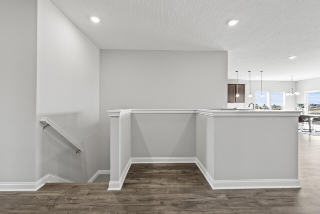 1304 Township Rd Unit 179, Bellefontaine, OH 43311 - corridor featuring baseboards, an upstairs landing, a textured ceiling, and dark wood-style floors
