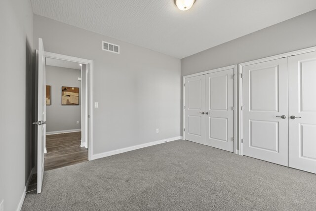 1304 Township Rd Unit 179, Bellefontaine, OH 43311 - unfurnished bedroom with visible vents, carpet floors, two closets, and baseboards